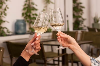white wine glasses clinking cheers
